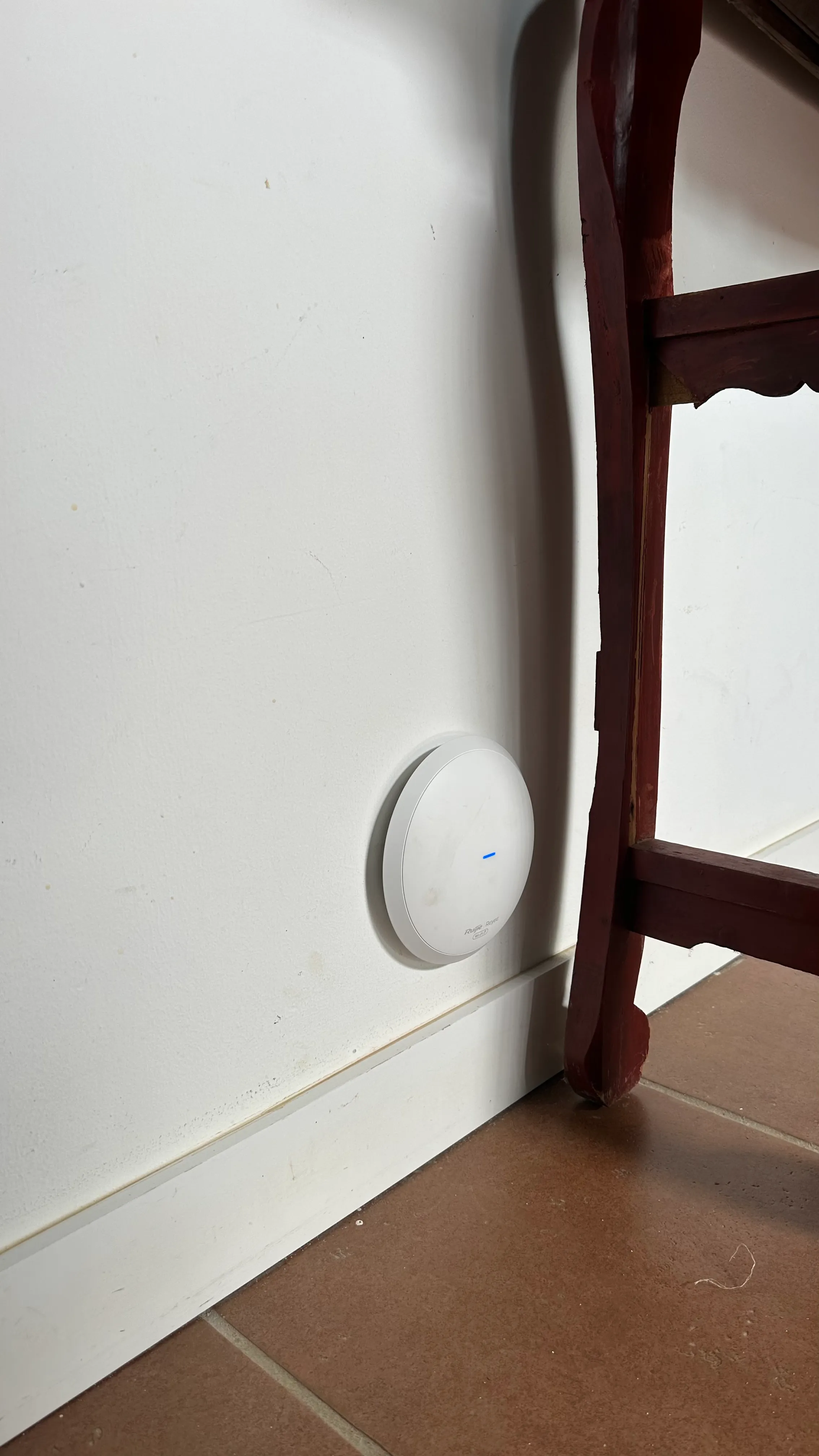 Punto de acceso Ruijie instalado en una pared junto a una estructura de madera